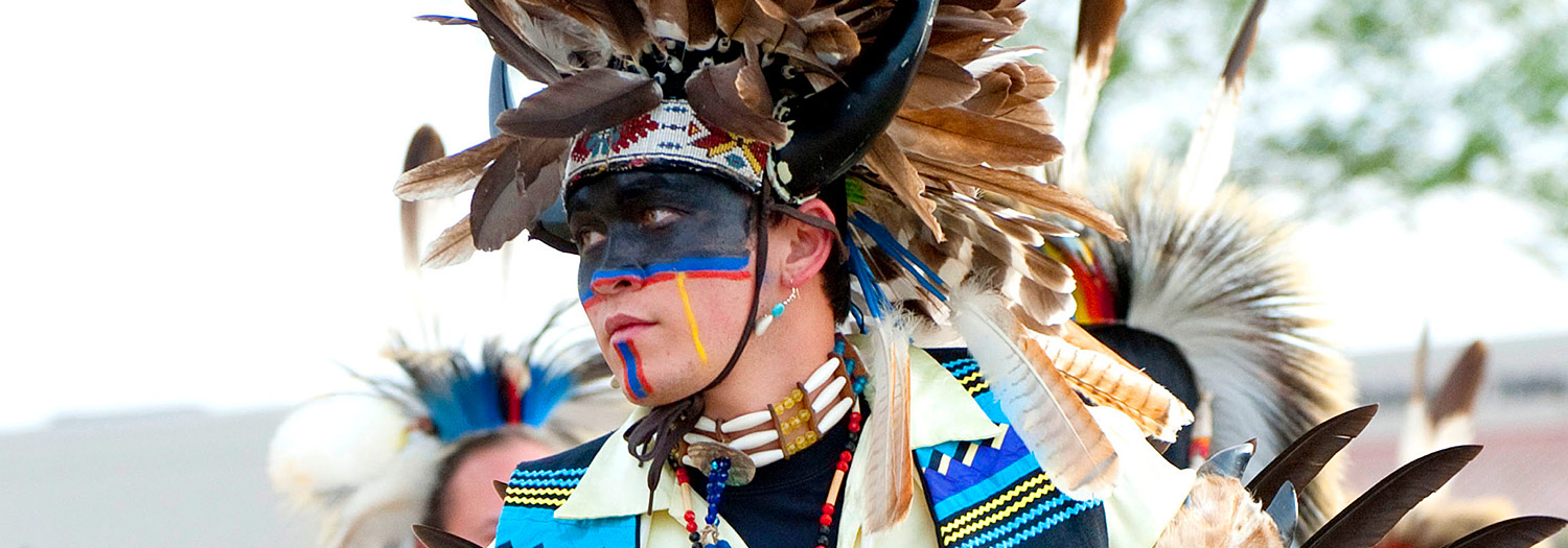 Young Native American male in full costume and face paint