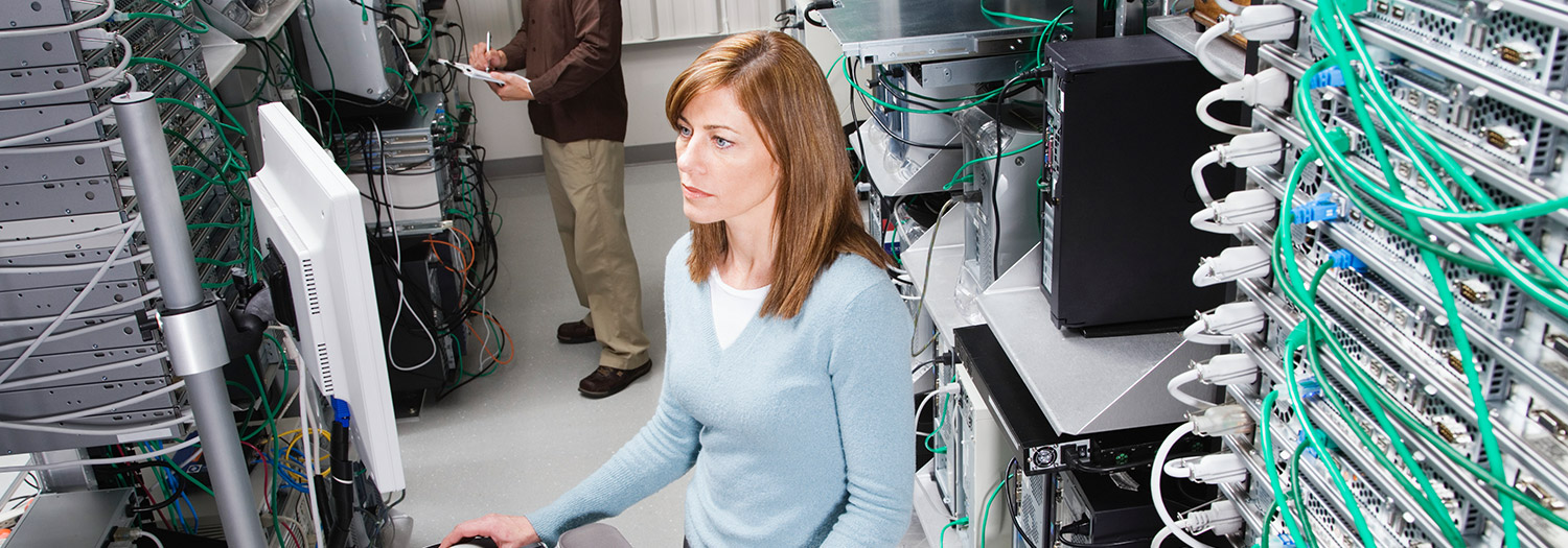 Young lady surrounded by network servers in racks