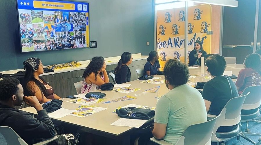 •	Students meeting around a table with an advisor.