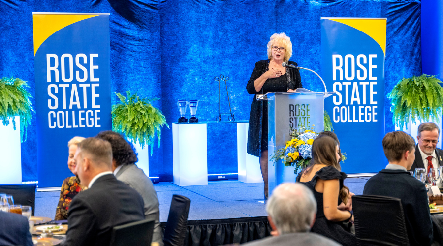 Cindy Mikeman, VP of the RSC Foundation, presents Distinguished Alumni awards to recipients Dean Fisher and John Primo