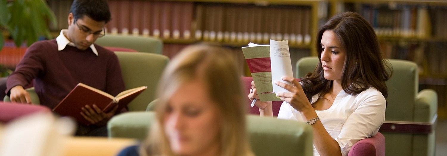 three students reading in the library