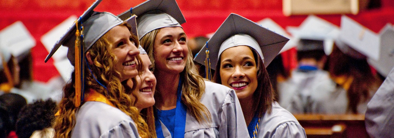 A group photo of happy graduates in their graduation attire.