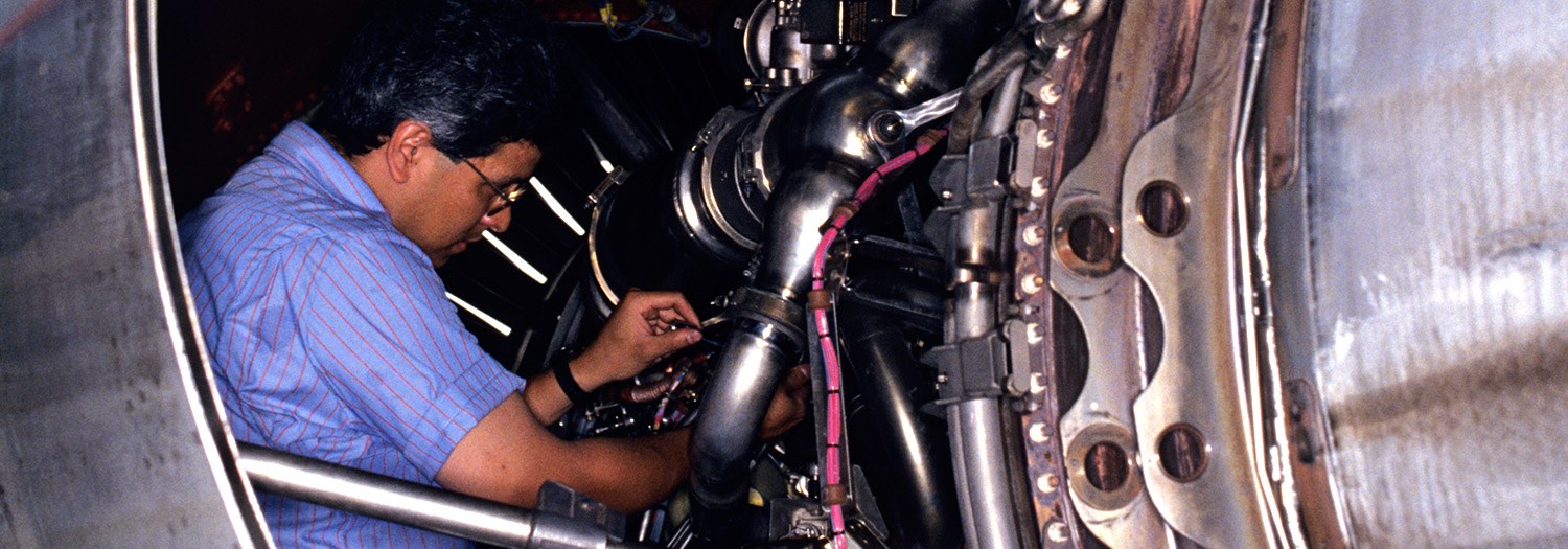 A mechanic working on an aircraft engine