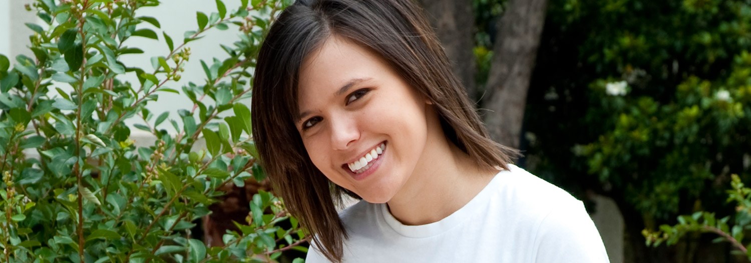 Smiling female student seated outdoors