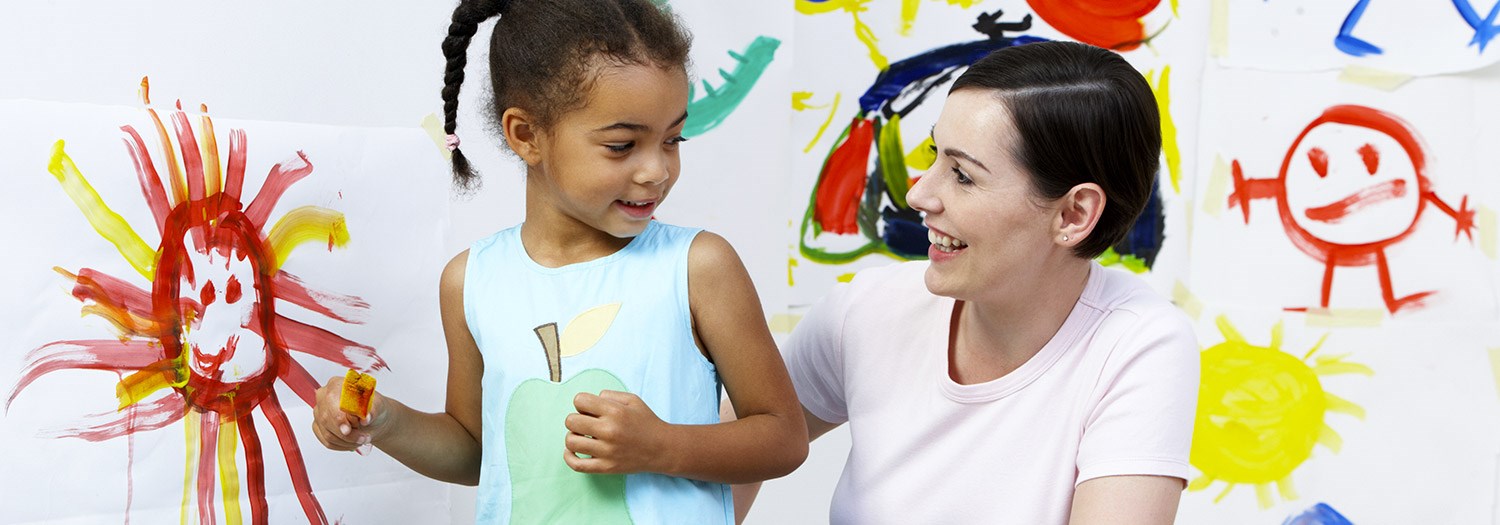 child and women surrounded by children's artwork