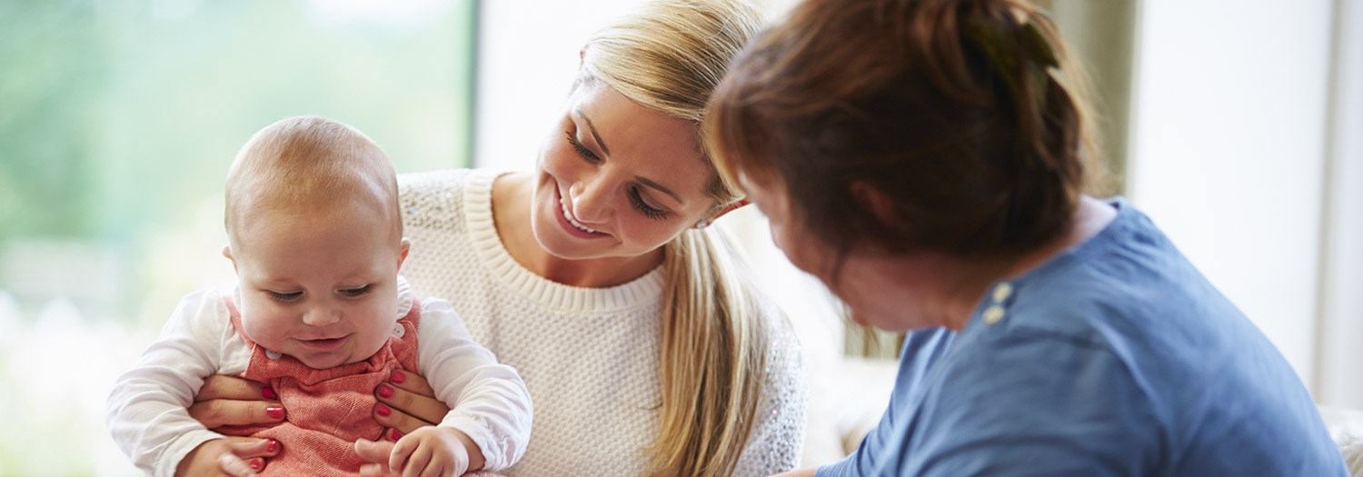 Two women holding a baby