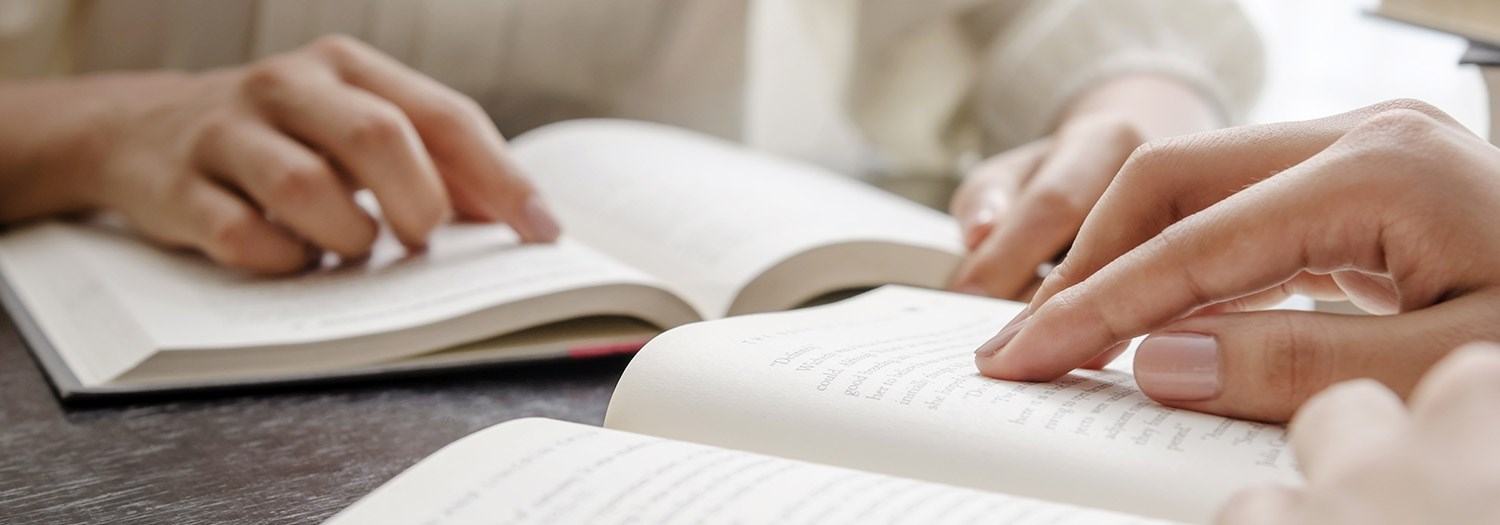 close up of two people reading books