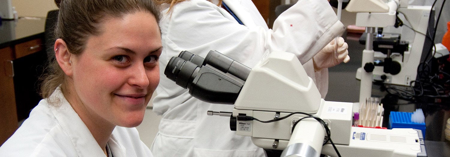 Young lady in front of a microscope