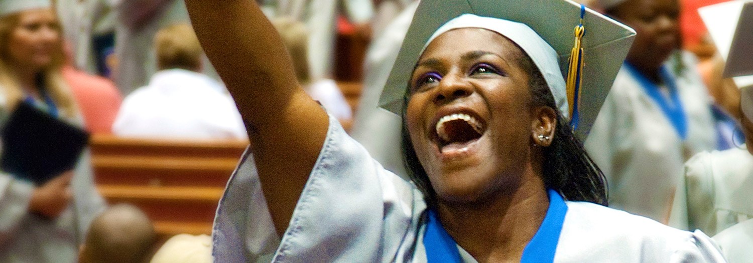 Smiling graduate in cap and gown