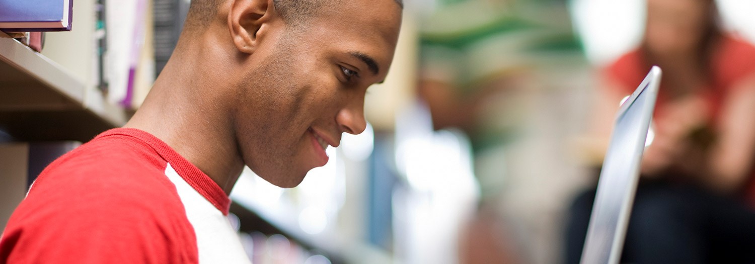 Male student looking at a laptop screen