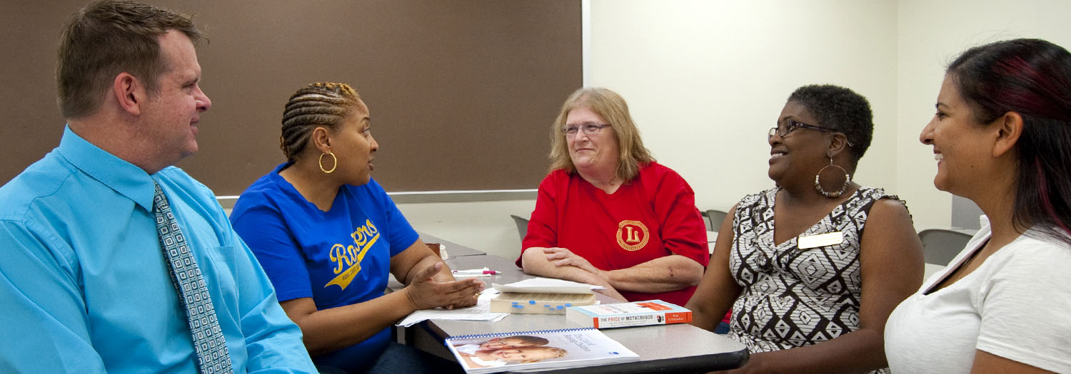 Grant coordinators discussing book "The Price of Motherhood"