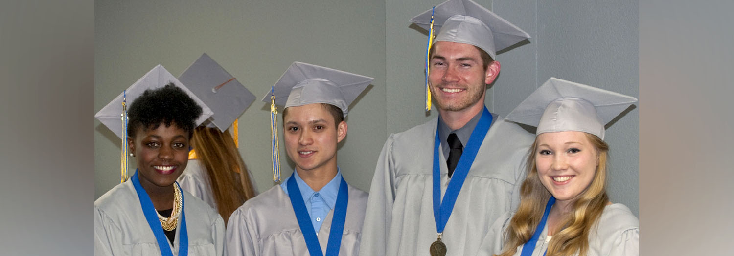 Four graduates pose for a photo