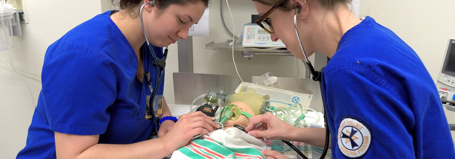 two nursing students working on a dummy