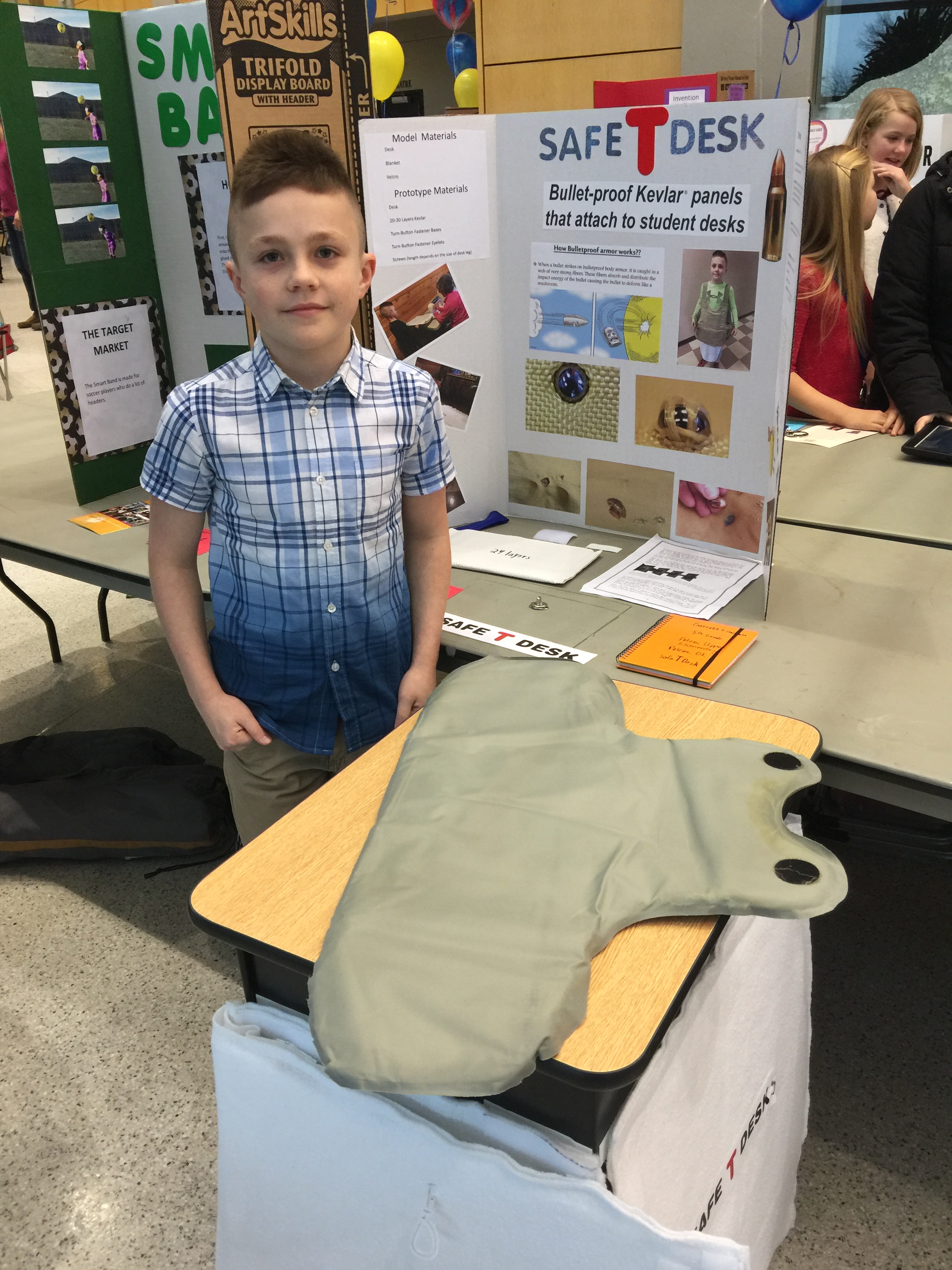 5th grader Garrett Finchum of Poteau at Rose State College with his invention, “Safe T-Desk”.