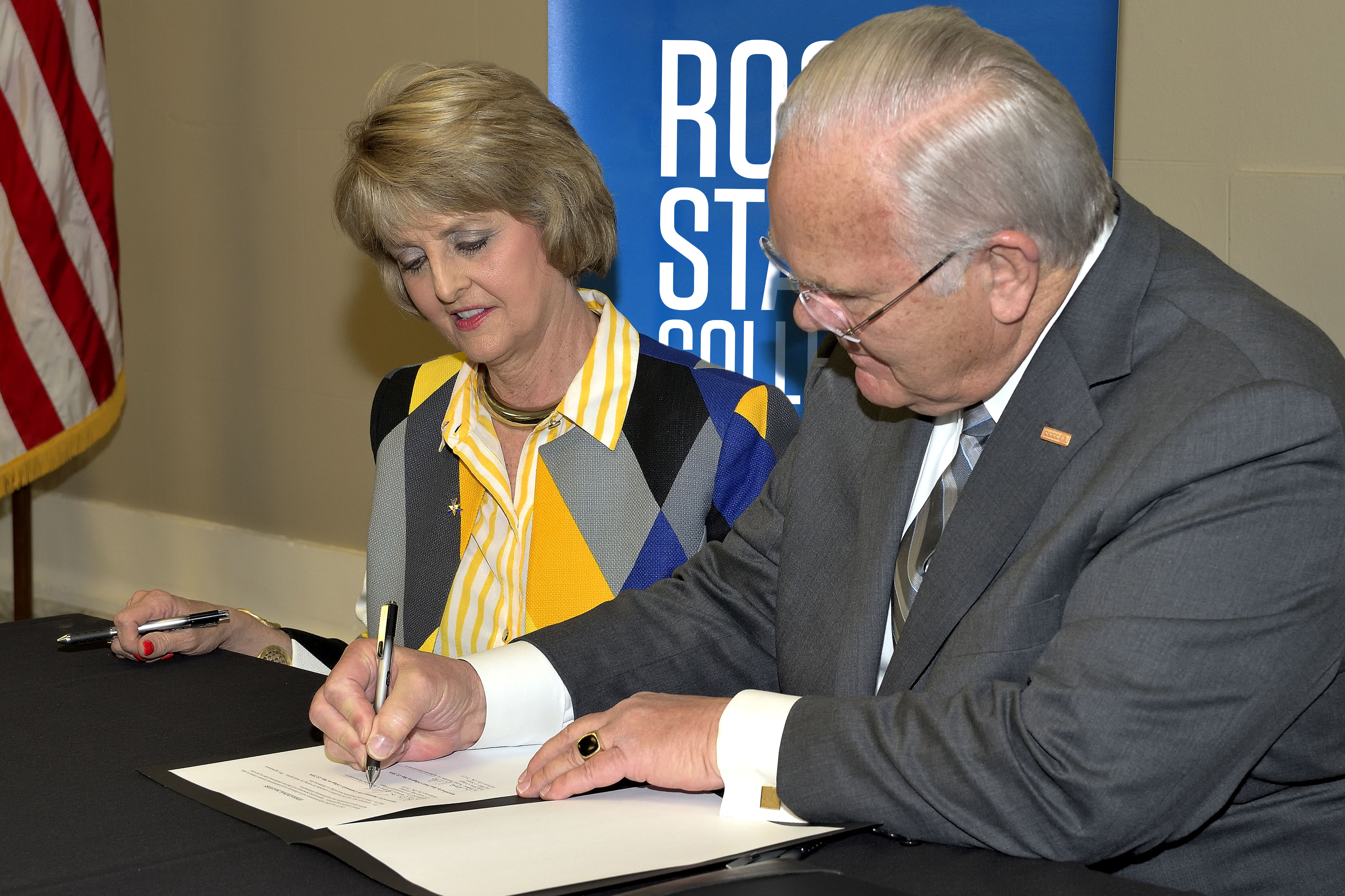 Rose State College President Jeanie Webb and Oklahoma City Community College President Jerry Steward sign the agreement for the colleges to partner on bidding for services.
